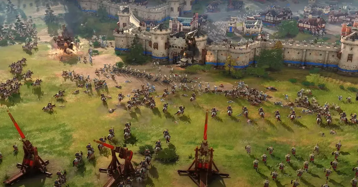 In-Game-Screenshot von Age of Empires IV, der eine groß angelegte mittelalterliche Belagerung mit Triböcken und Kavallerieeinheiten zeigt