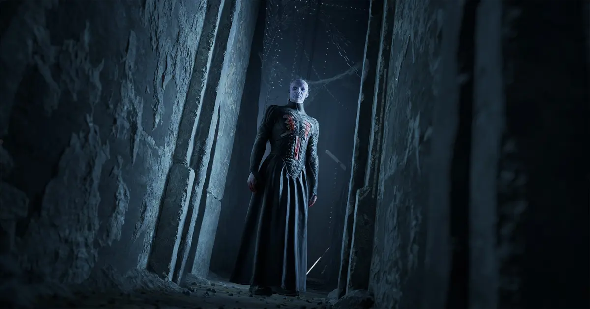 Der Anführer der Zenobiten, Pinhead, steht in einem dunklen, labyrinthischen Korridor und starrt den Protagonisten Aidan an.